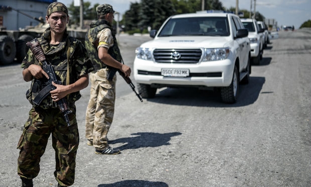 Em carros brancos inspetores da Osce são escoltados por soldados. / Foto: Bulent Kilic/ AFP