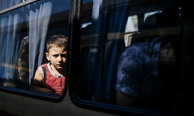 Pessoas embarcam em ônibus para deixar a fronteira de Donetsk. / Foto: Dimitar DilkoffF / AFP