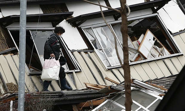 Moradora deixa residência após resgatar poucos pertences / Foto: AFP