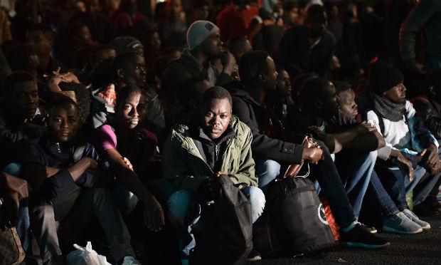 Os migrantes, em sua maioria sudaneses, afegãos e eritreus - incluindo mulheres e crianças - eram retirados em ônibus. / Foto: Chistophe Archabault / AFP