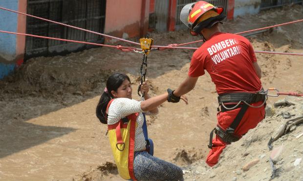Os bombeiros e policiais retiraram centenas de pessoas dos bairros atingidos usando cordas / Foto: AFP