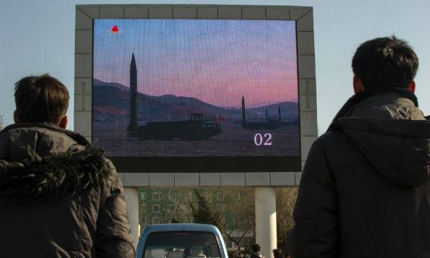 Pessoas assistem à notícia de um lançamento do míssil em uma tela gigante da televisão em Pyongyang no dia 7 de março / Foto: AFP